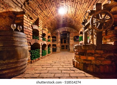 Small And Old Wine Cellar With Many Full Bottles And Keg