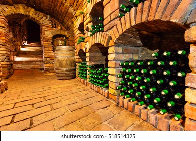 Small And Old Wine Cellar With Many Full Bottles And Keg