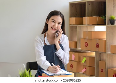 Small Online Business Owner Smiling Beautiful Talking On The Phone. Looking At The Camera.