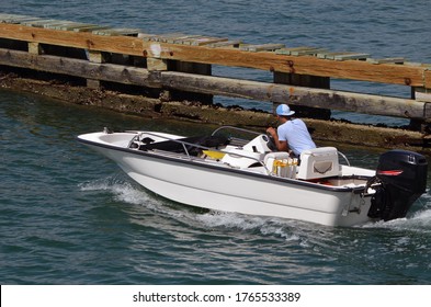 A Small Open Fishing Skiff Powered By One Outboard Engine.