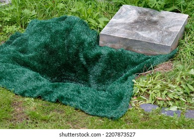 Small Open Grave Covered With A Green Mat Before Urn Burial In A Cemetery