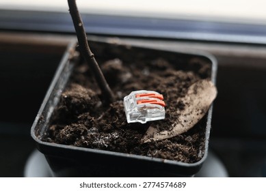 Small orange and clear electrical wire connector on textured surface