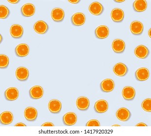 A Lot Of Small Orange Cut In Half On A Light Blue Background With Large Size Shadows In The Middle Is Empty For Writing