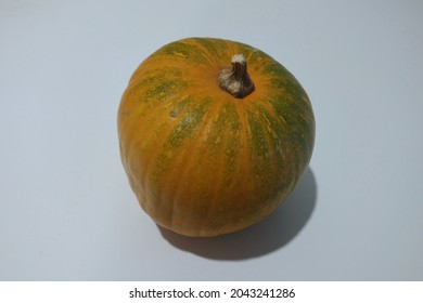Small orange and green pumpkin on a white background from organic farming