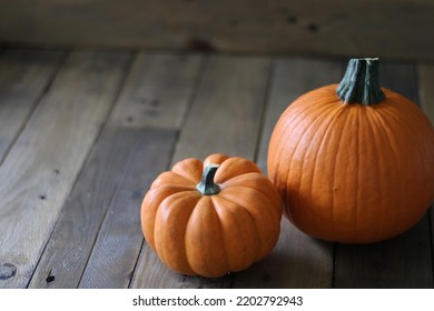 Small Orange Pumpkins On Rustic Barnwood Table