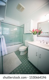 Small Outdated Tile Bathroom With A Clear Glass Door And A White Cabinet Sink Vanity And Mirror