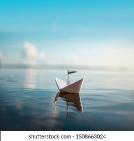 Small Paper Ship floating on Water - Powered by Shutterstock