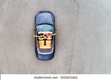 Небольшой пассажирский спортивный кабриолет автомобиль с мягким сверху вниз и счастливой парой молодых женщин, наслаждающихся стилем жизни и свободой в воздухе сверху вниз вид.