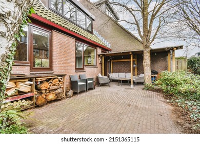 Small Patio With Gray Sofa And Armchairs And Wooden Table Under Canopy