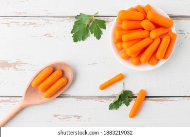 Small Peeled Pieces Of Carrot In Plate On The White Wooden Table. Top View.