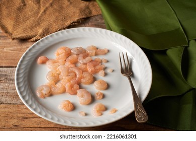 Small Peeled Prawns On A Plate And Rustic Wooden Table