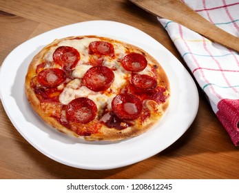 Small Pepperoni Pizza In A Plate On A Wooden Table