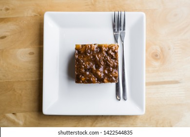 Small Piece Of Brownie Cake In White Plate On Wood Table