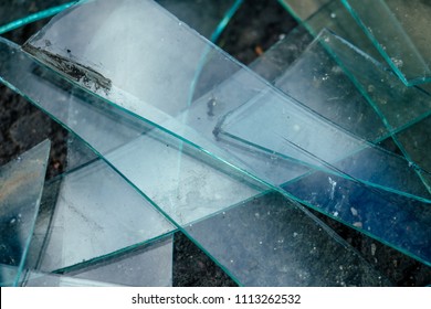 A Small Pile Of Broken Glass Lying On The Asphalt