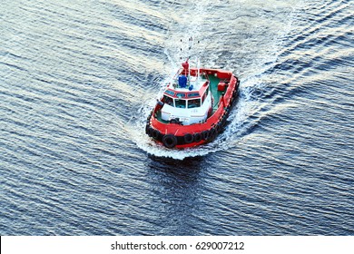 A small pilot boat sails on the sea. Texture of blue water in the sea on the sunset                         