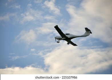 Small Plane In The Air. Blue Sky With White Clouds.