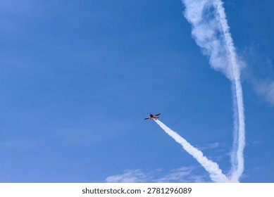 Small plane during demonstration flight emitting white smoke