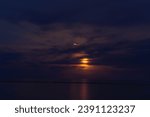 Small plane flying near the Flower Moon over lake Michigan Racine. WI