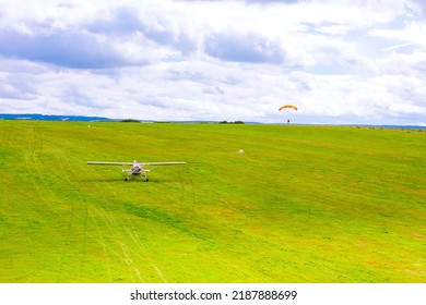 Small Plane On A Green Field, Paratrooper Landing On A Green Field. Air Entertainment. View From Above.