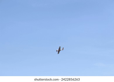 A small plane in the sky with space for text. Single plane flies lonely in the clear blue sky. Single propeller aircraft flying in heaven.