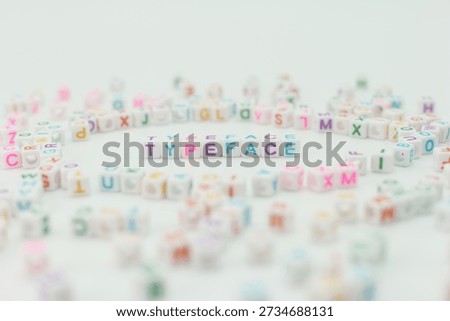Small plastic cubes with letters are arranged in a round shape. The word typeface stands out in the center. Various other letters fill the space around it.