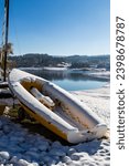 Small pleasure boat under the first snows of winter on the shore of Lake Lavalette in the Gorges du Lignon
