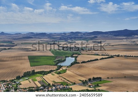 Small pond or water reservoir in the cultural country of Central Bohemian Uplands in Czech Republic. Countryside with intensive agricultural crop production. Picture is taken in summer sunny day. 