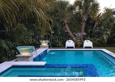 Small pool oasis surrounded by a lush, tropical landscape at sunset.