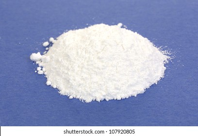 A Small Portion Of Calcium Citrate Powder On A Blue Background.