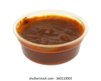 A Small Portion Of Marinara Sauce In A Plastic Container Isolated On A White Background.