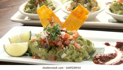 Small Portion Of Mexican Organic Guacamole With Fried Plantain And Chipotle Salsa From Above