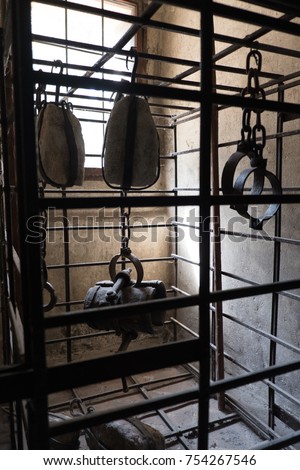 Small prison cell with manacles handing from chains. Medieval torture prison cell in Czech Republic. Small jail cell to torture and imprison criminals.