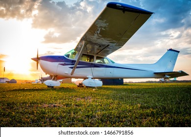 Small private airplanes on the airfield against the backdrop of a colorful sunset - Powered by Shutterstock