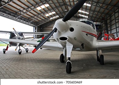 Small private lightweight propeller airplanes in hangar. - Powered by Shutterstock