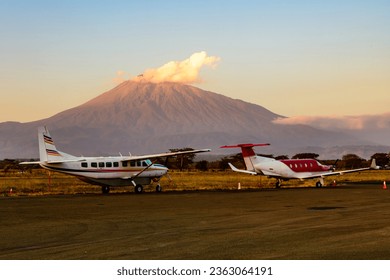 Small propeller airplanes at airport at sunset, mount Meru at background. Arusha, Tanzania - Powered by Shutterstock