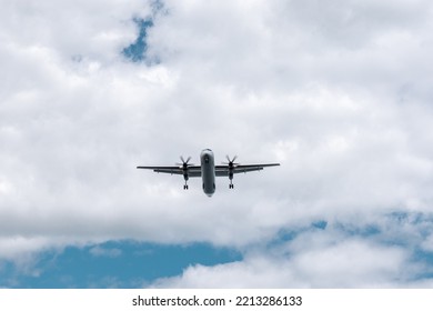 Small Propeller Plane Flying Above The Head Before Landing. Bottom Of The Plane On The Sky