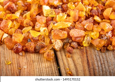 Small Raw Amber On A Wooden Table. A Precious Find From The Coast Of Central Europe. Light Background.