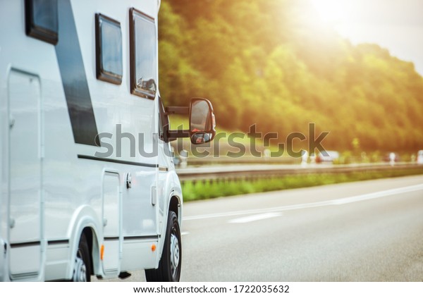 Small Recreational Vehicle Riding On Highway During\
Summer Time. 