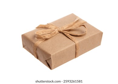 Small rectangular gift box wrapped in brown kraft paper and tied with a rustic twine bow. Eco-friendly and minimalist packaging, isolated on a white background