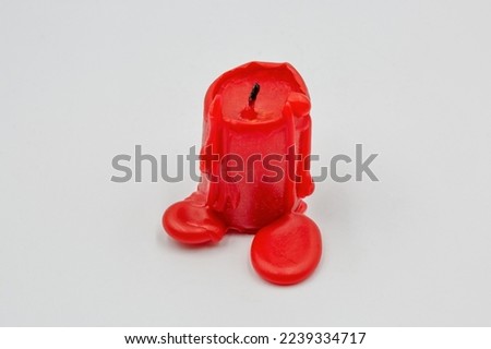 small red candle stub closeup on white background
