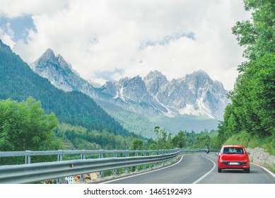 Small Red Car On The Road Through Mountains Road Trip Copy Space