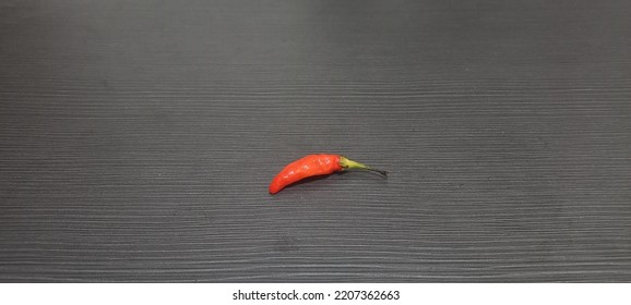 A Small Red Chili On A Wooden Table
