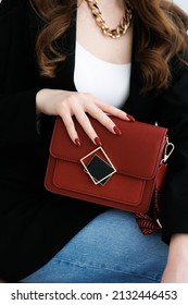 Small Red Handbag. Fashionable Women's Leather Clutch Bag With A Fabric Strap In The Tone Of The Shoes. Girl . Traditional Clutch Bag With Brooch. Bag Made Of Fine Red Genuine Leather. Front View. 