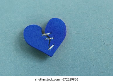 Small Red Heart, Broken With Threaded Stitches