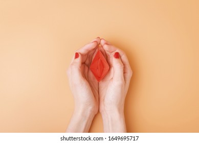 kleines rotes Papierboot in weiblichen Palmen. Abstraktes Bild der Vagina