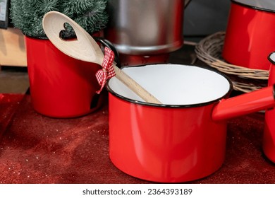 a small red pot with a decorative cooking spoon - Shutterstock ID 2364393189