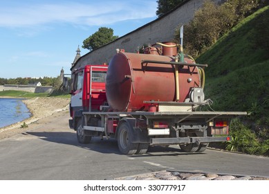 Small Red Sewage Truck On The River Bank