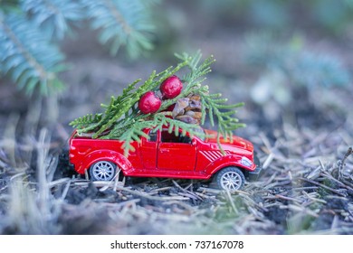 Small red toy car with christmass tree and red berries - Powered by Shutterstock