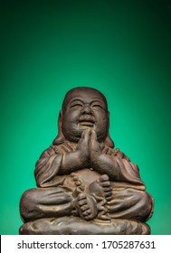 A Small Replica Statue Of The Buddha With A Green Background.  Green Symbolizing Cleanliness And Purity From Contamination.