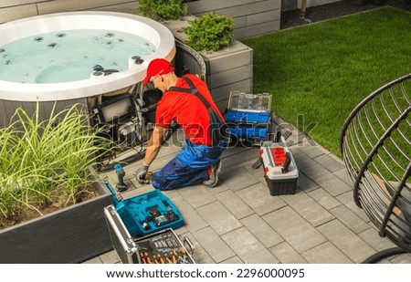 Small Residential Hot Tub Maintenance Performed by Caucasian SPA Technician.